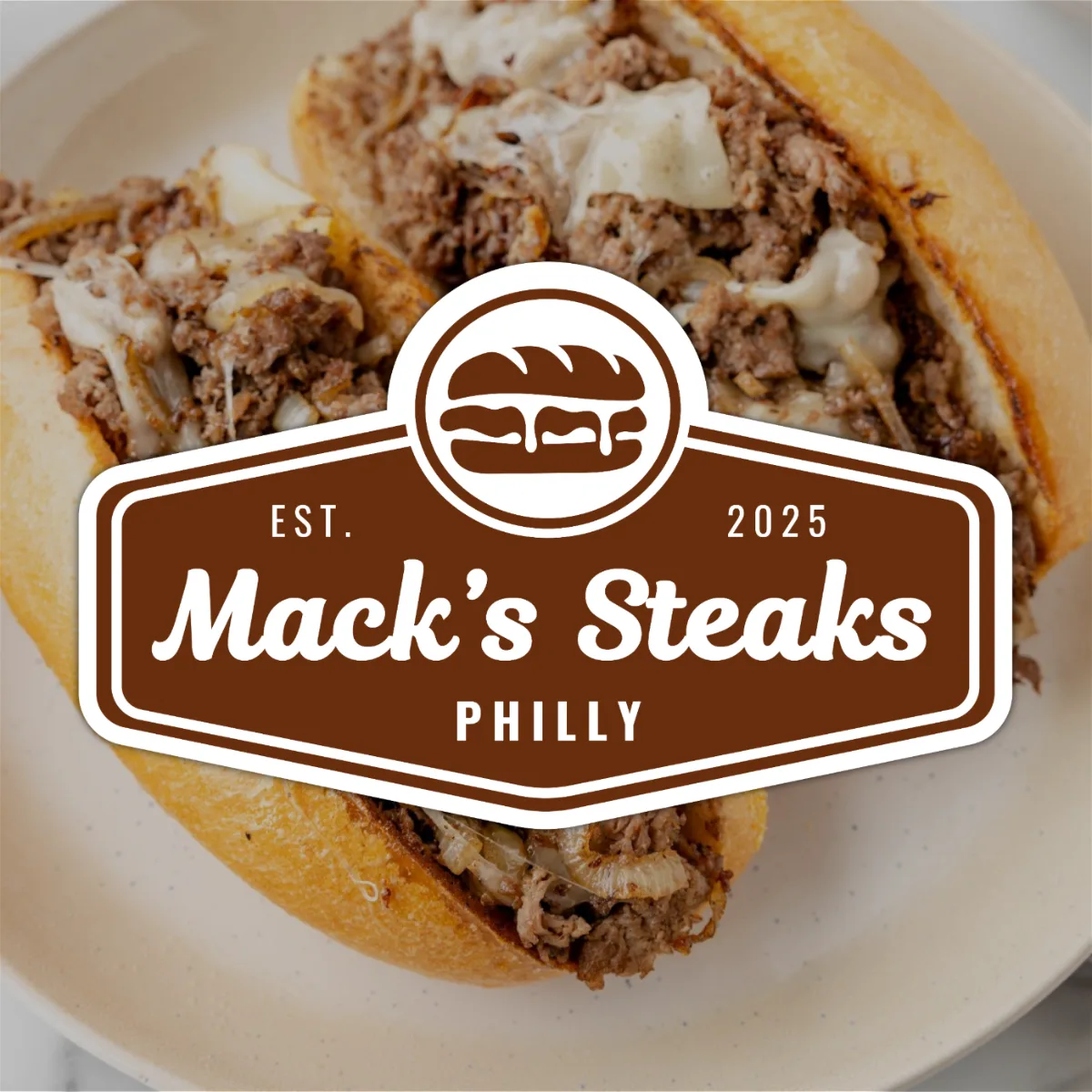 Mack's Steaks Philly badge logo over a cheesesteak sandwich